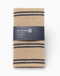 Folded linen tea towel with blue stripes and 'The Sea Shed' label on a white background. Striped linen tea towel
100% linen tea towel
Hand-loomed linen tea towel
Natural linen kitchen towel
Coastal linen tea towel